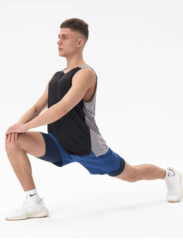 Man stretching in a gym wearing a breathable double color tank top, black and gray, perfect for workouts. SF1813 model.